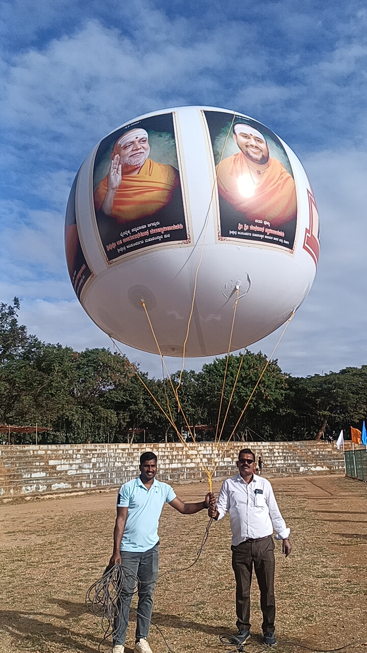 Large printed sky balloon flown at a community event ground in Karnataka